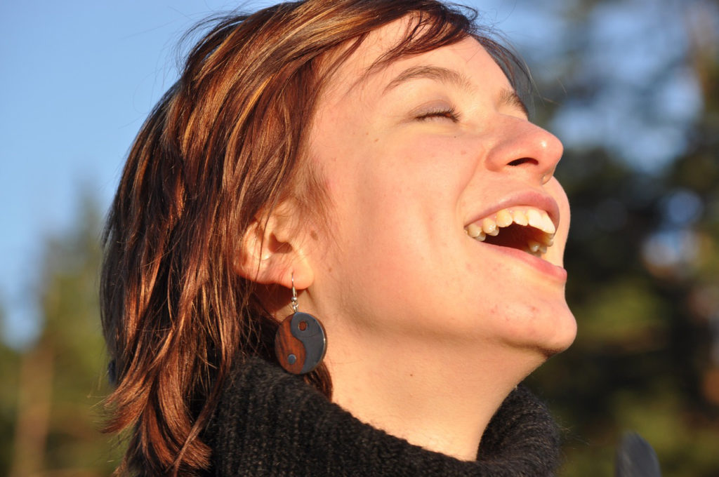 femme souriante, visage exposé à la lumière naturelle